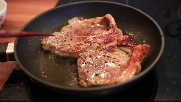 Đặt chảo dầu nên trên bếp đun cho nóng và cho thịt vào chiên qua – cách làm bò bít tết