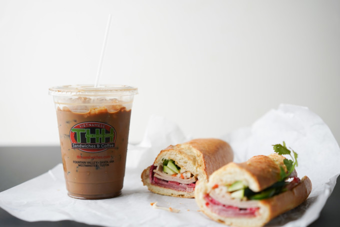 takeout cup of Viet coffee and two banh mi sandwiches